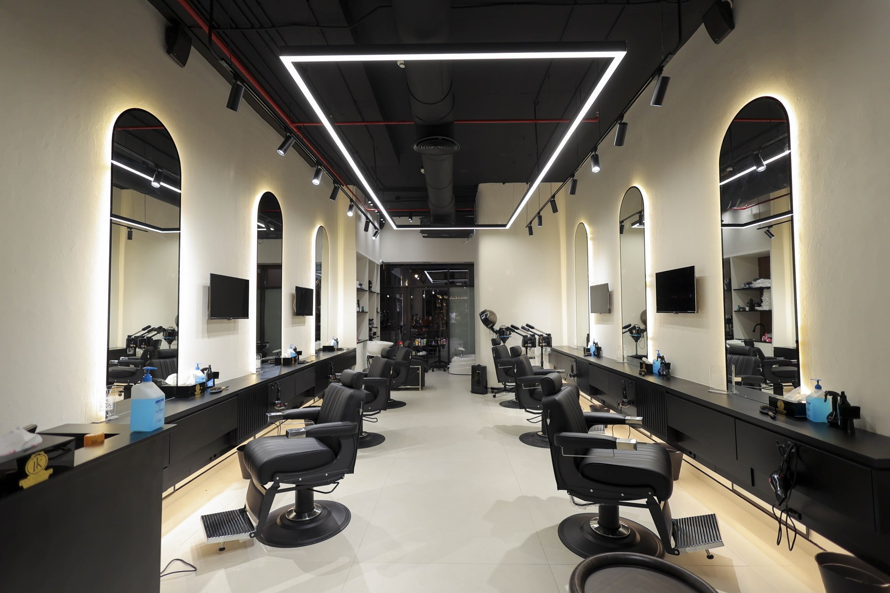 Inside The Kut Lounge in Madinaty — barber chairs and arched backlit mirrors